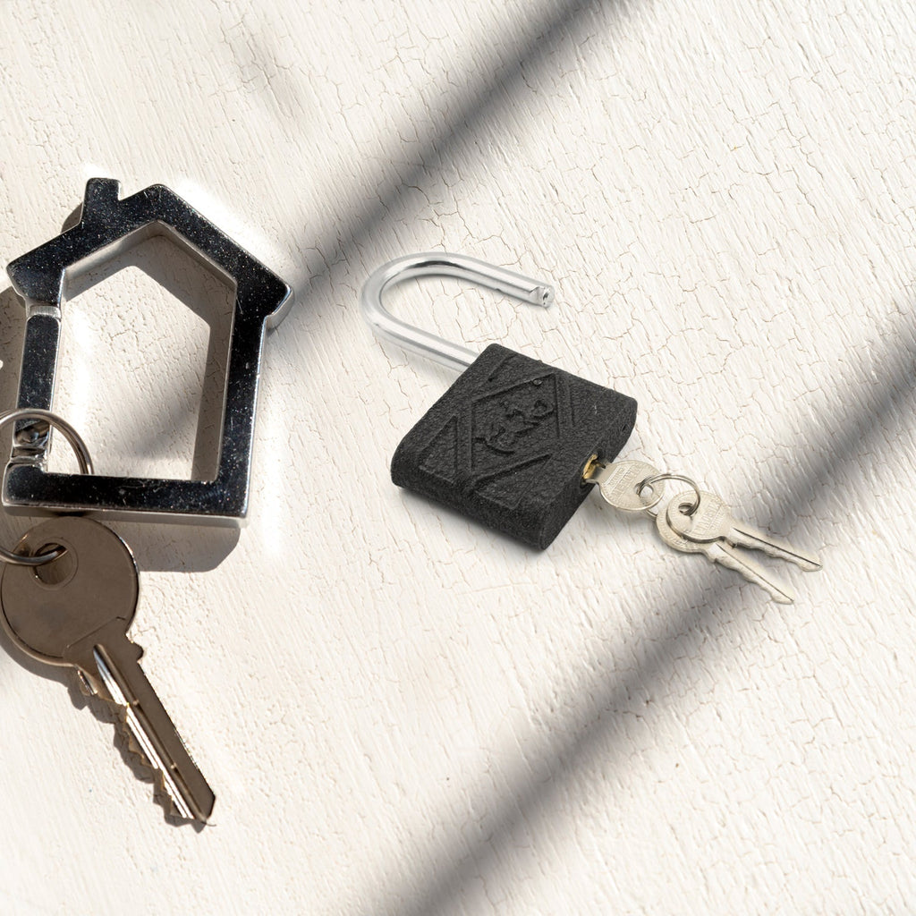 The black iron padlock resting securely on a textured wooden surface.